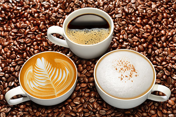 Mugs of cuffee surrounded by coffee beans and vending machines